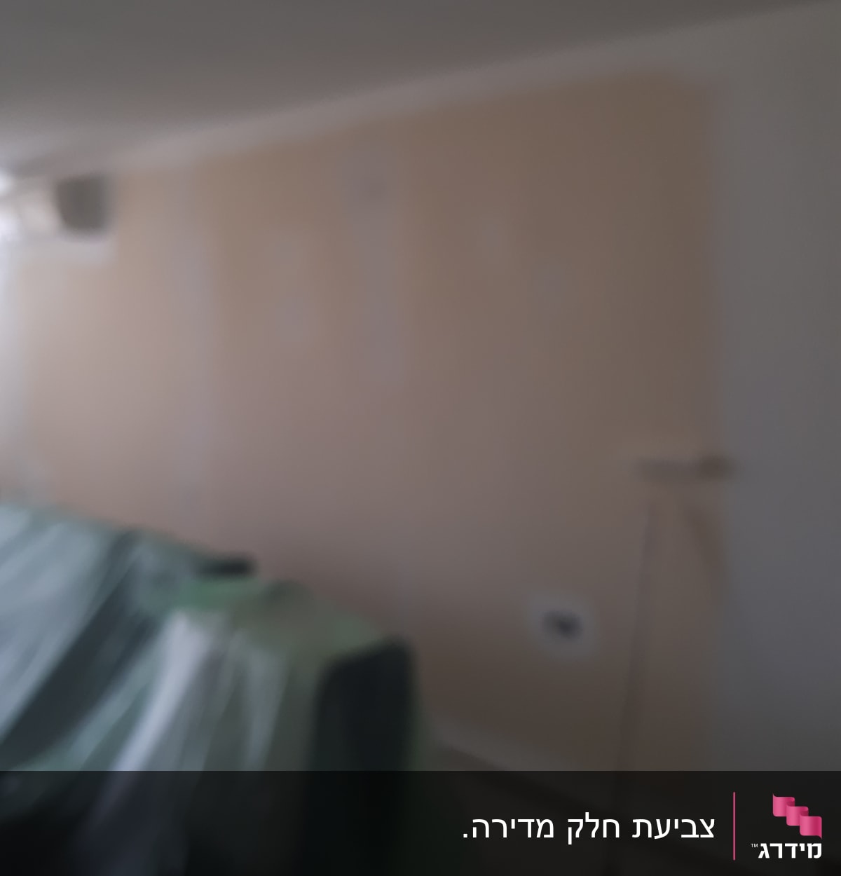 קיר צבוע חלקית עם רולר צביעה